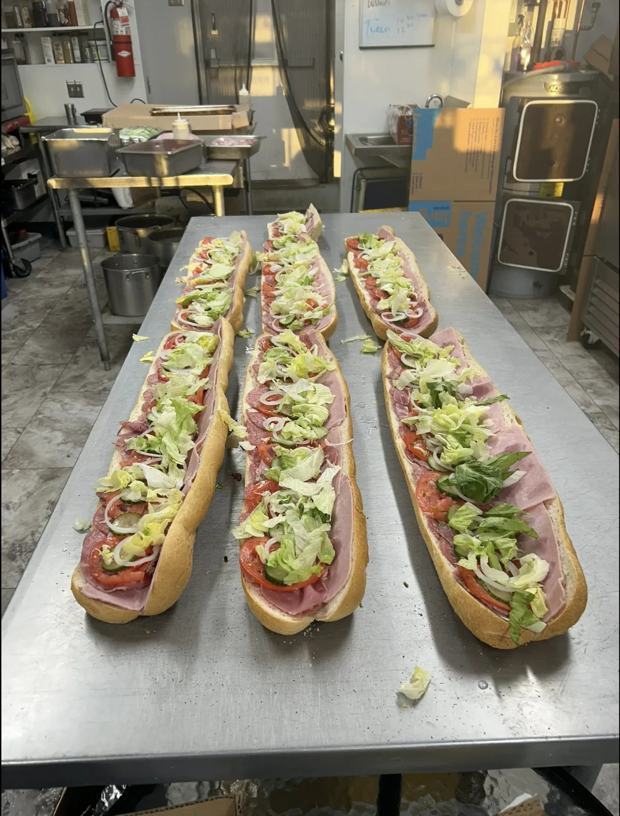 Six three-foot Italian subs built to order on the prep table at TEE's Deli